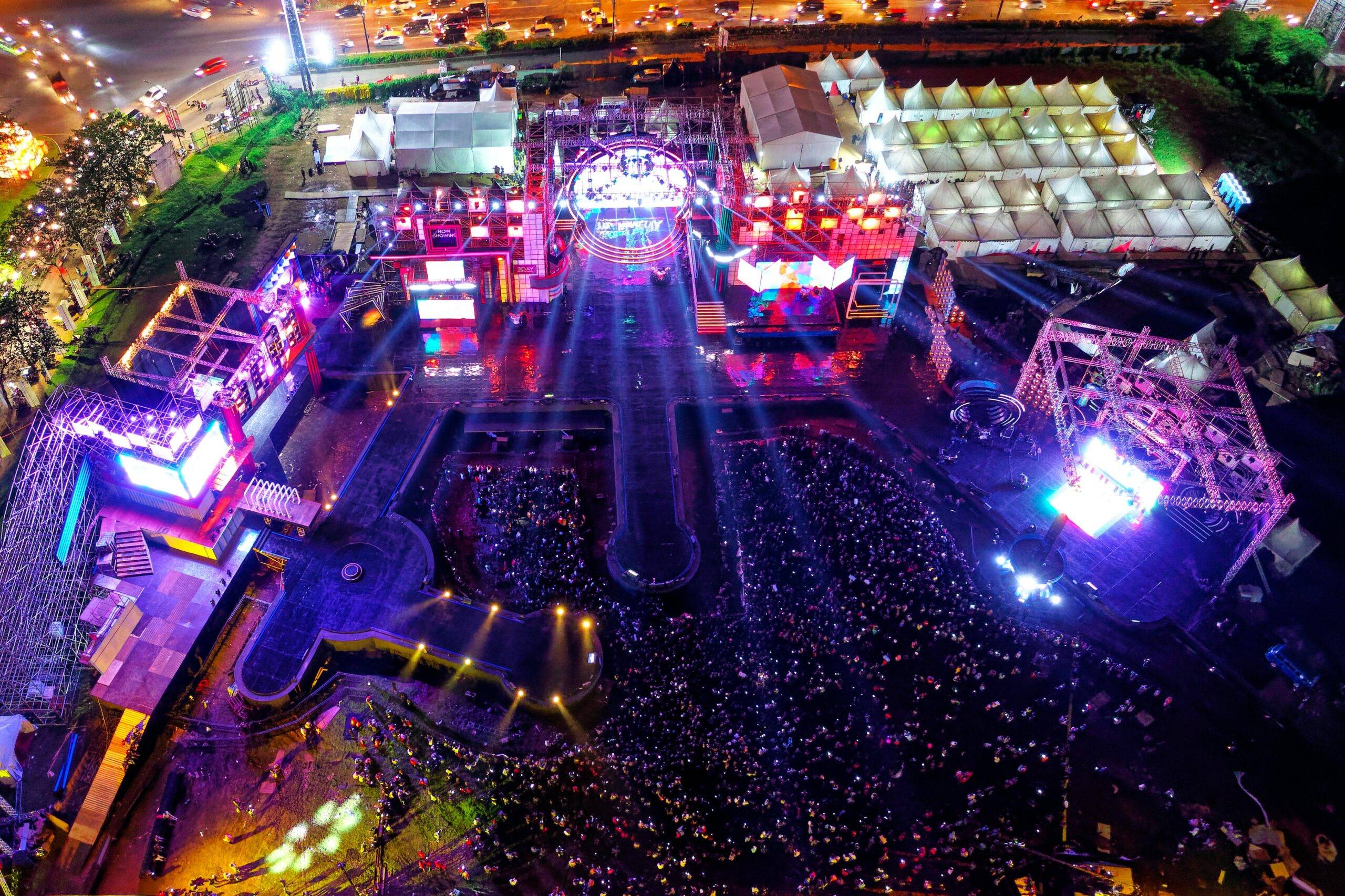 Aerial view of a vibrant music festival in Serpong, Indonesia with crowds and stage lights.